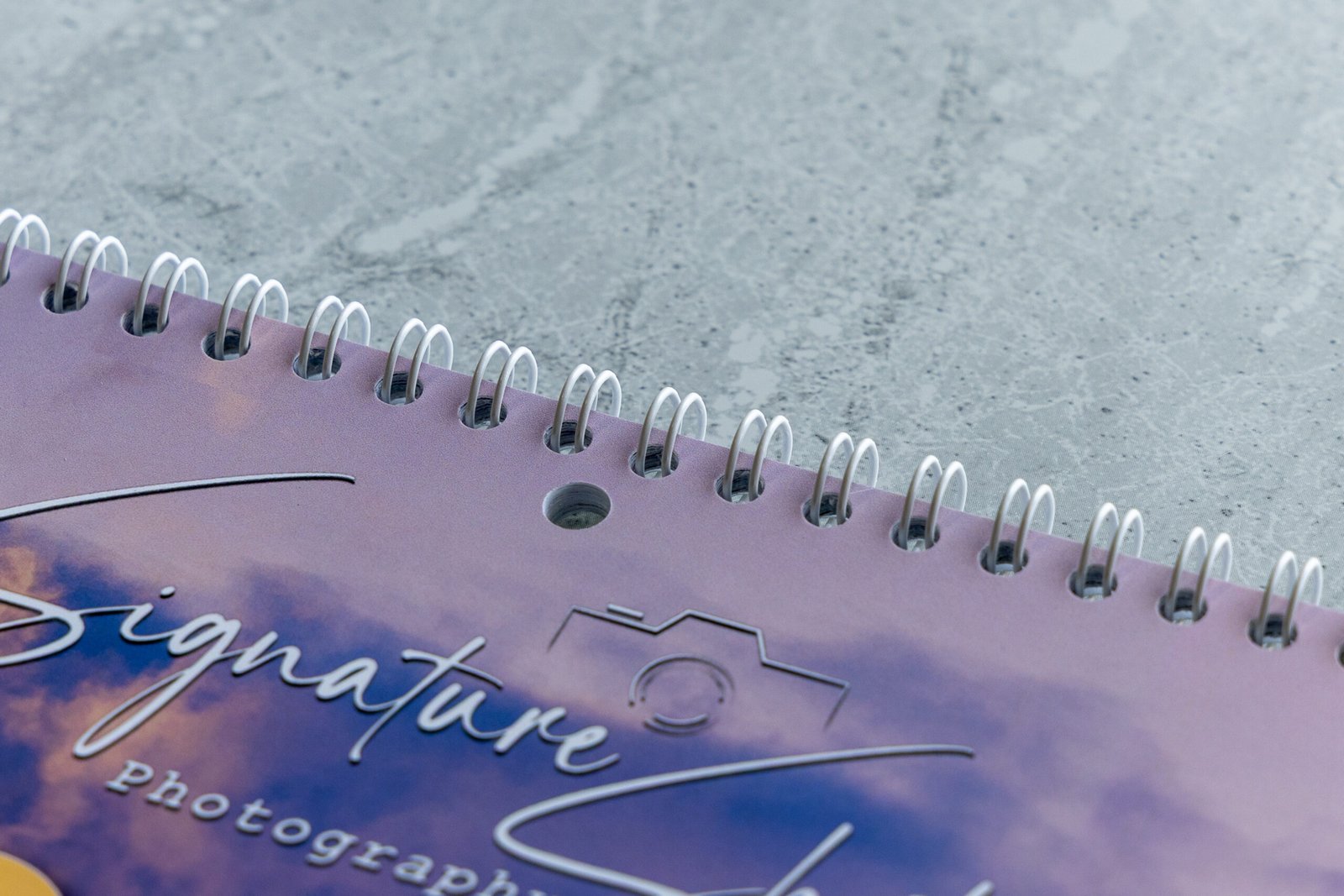 Close-up of the premium white wire binding and hanging hole