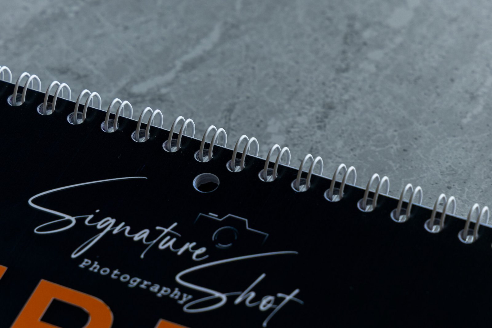 Close-up of the premium white wire binding and hanging hole