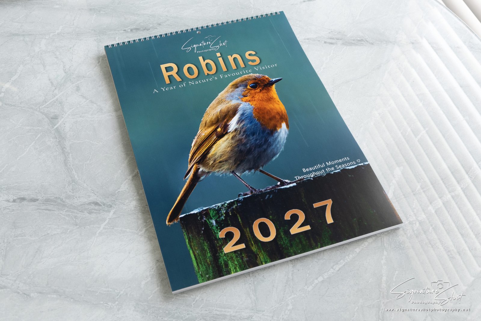 Complete Robin 2027 calendar photographed on a premium marble surface